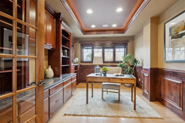 office area featuring a raised ceiling, wainscoting, ornamental molding, light wood-type flooring, and recessed lighting