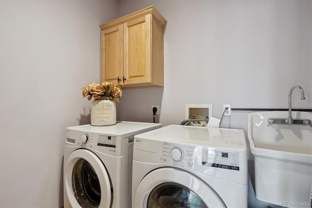 laundry area with washer and clothes dryer, a sink, and cabinet space