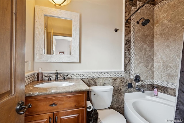 full bathroom with wainscoting, toilet, vanity, tile walls, and shower / bathing tub combination