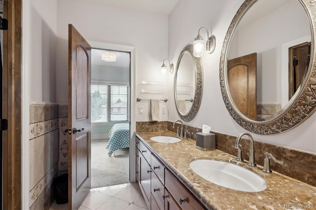 bathroom with tile patterned flooring, a sink, and double vanity