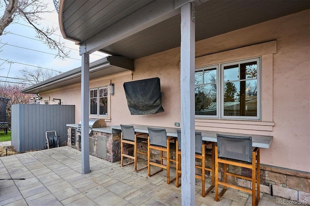 view of patio featuring exterior kitchen, outdoor wet bar, and area for grilling