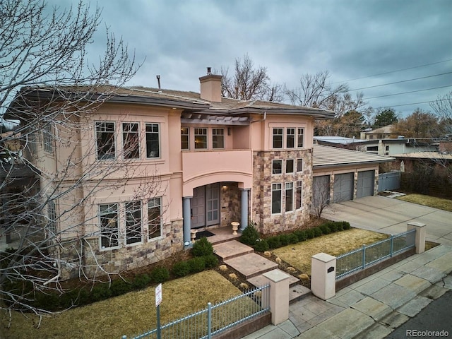 view of front of property with a fenced front yard, a chimney, stucco siding, an attached garage, and stone siding