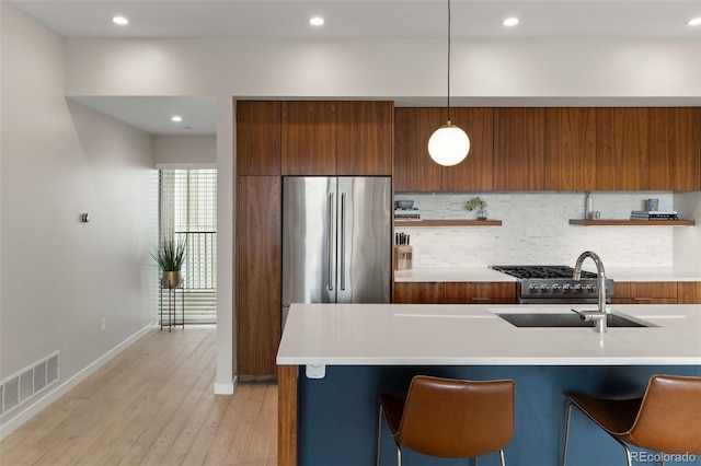 3233 Tejon St Unit 305, Denver, CO 80211 - kitchen with modern cabinets, brown cabinetry, backsplash, light wood-type flooring, and light countertops