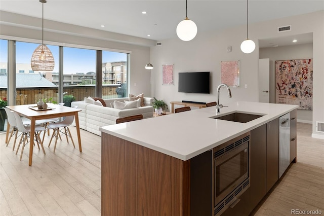 3233 Tejon St Unit 305, Denver, CO 80211 - kitchen featuring appliances with stainless steel finishes, plenty of natural light, light wood-style flooring, light countertops, and recessed lighting