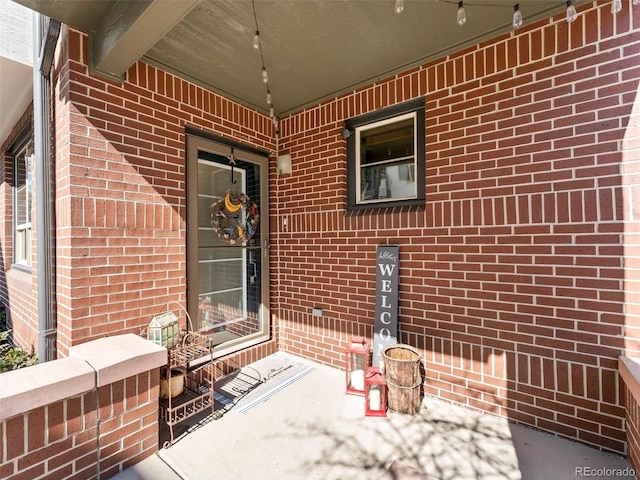 view of exterior entry featuring brick siding