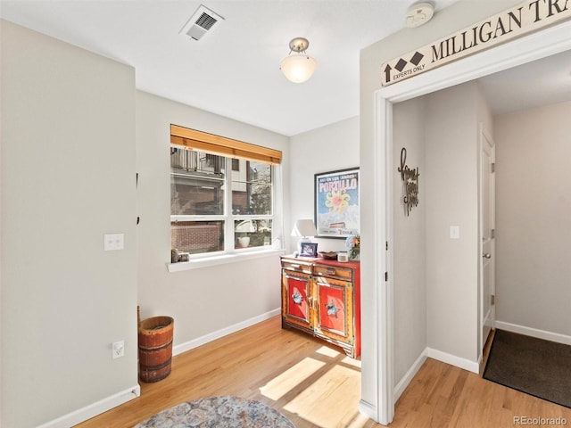 foyer featuring wood finished floors, visible vents, and baseboards