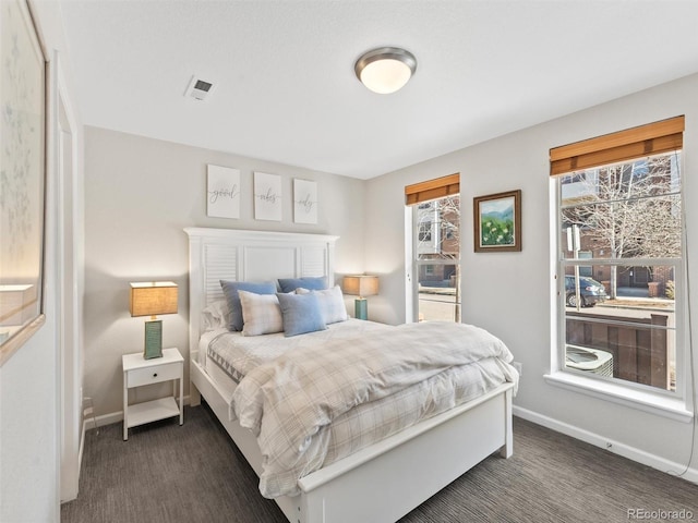 bedroom with baseboards, visible vents, and dark colored carpet