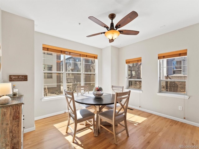 dining room featuring light wood-type flooring, ceiling fan, and baseboards