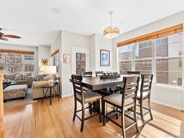 dining area with light wood-style flooring, baseboards, and ceiling fan