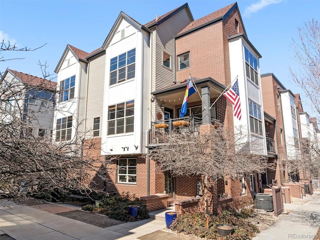 view of front of home featuring brick siding and central air condition unit