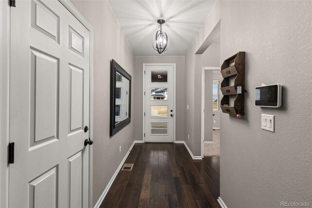 entryway featuring dark hardwood / wood-style floors and a chandelier