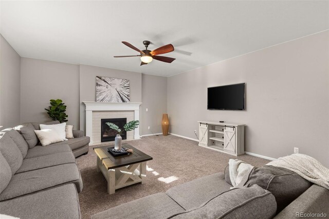 carpeted living room featuring ceiling fan and a fireplace