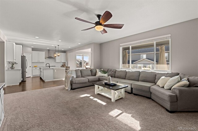 carpeted living room featuring ceiling fan