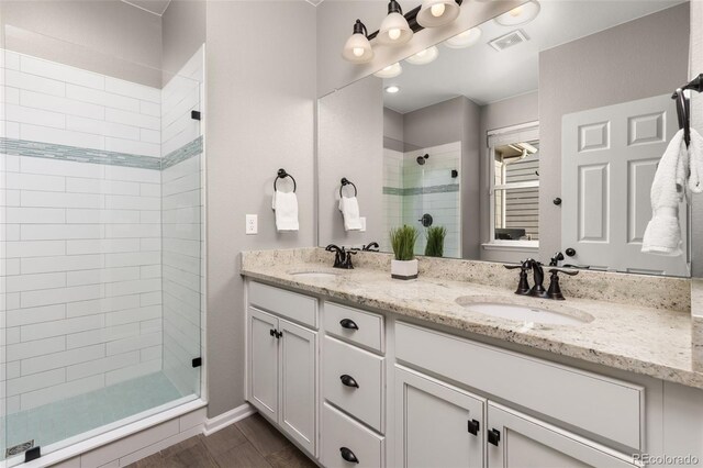 bathroom featuring a tile shower and vanity