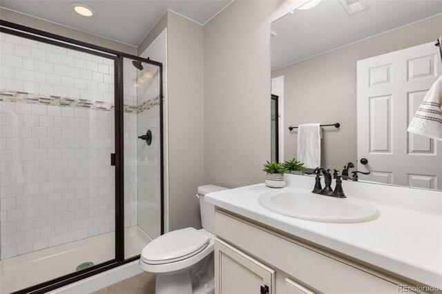 bathroom featuring vanity, toilet, and a shower with shower door