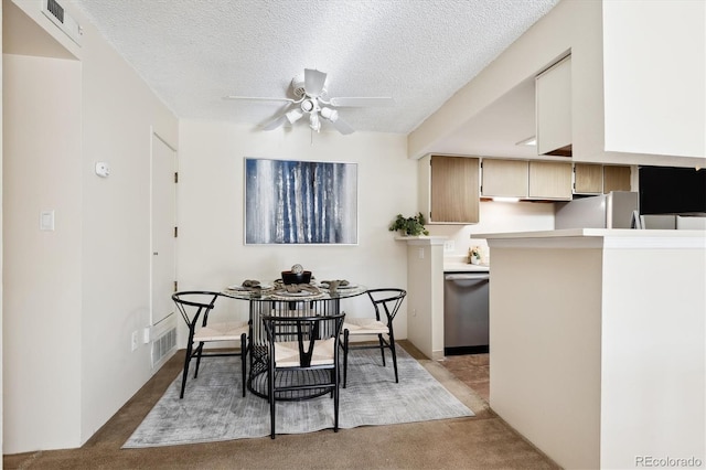 carpeted dining room featuring ceiling fan and a textured ceiling