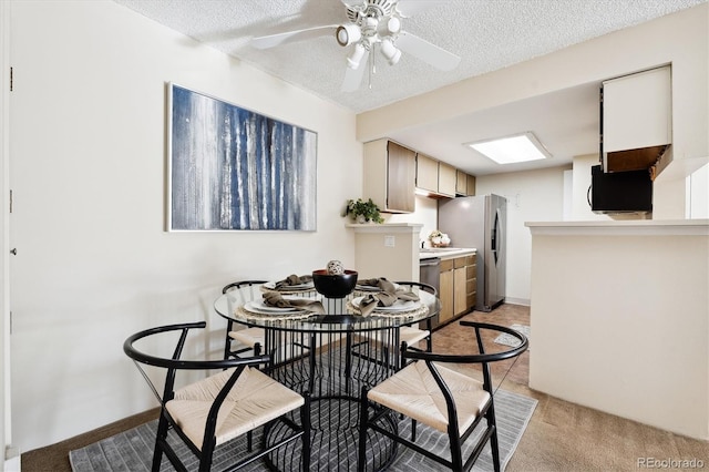 carpeted dining area featuring ceiling fan and a textured ceiling