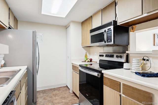 kitchen with light brown cabinets, stainless steel appliances, and sink