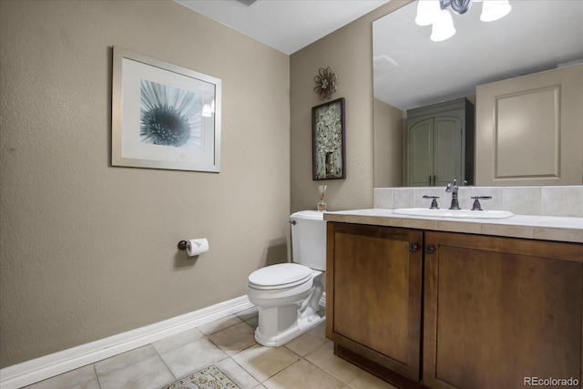 bathroom featuring tile patterned floors, toilet, baseboards, and vanity