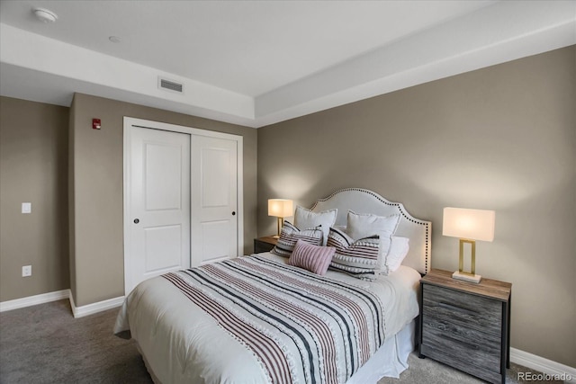 bedroom featuring baseboards, carpet flooring, a closet, and visible vents