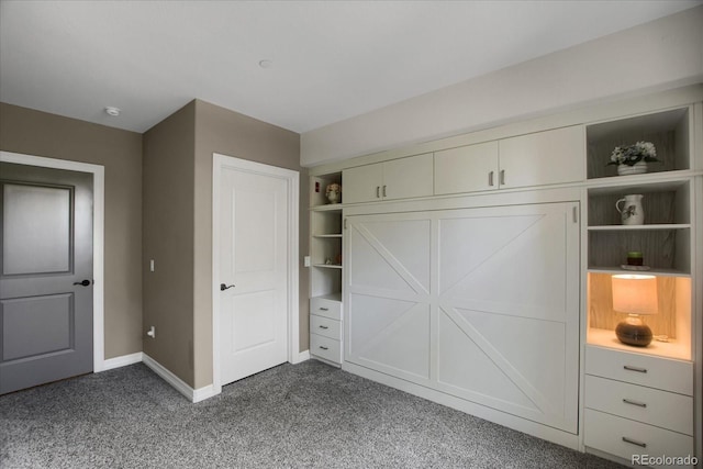 unfurnished bedroom with dark colored carpet and baseboards