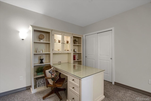 carpeted home office featuring built in study area and baseboards