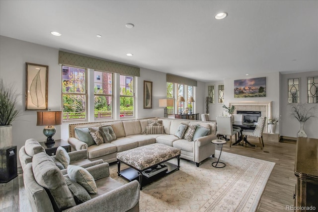 living area featuring recessed lighting, wood finished floors, and a tile fireplace