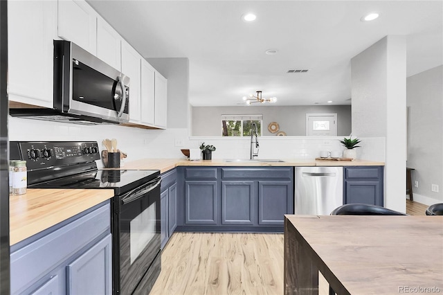 11757 W Tufts Pl, Morrison, CO 80465 - kitchen with stainless steel appliances, butcher block counters, a sink, and recessed lighting