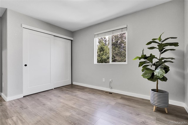 11757 W Tufts Pl, Morrison, CO 80465 - unfurnished bedroom with baseboards, wood finished floors, and a closet