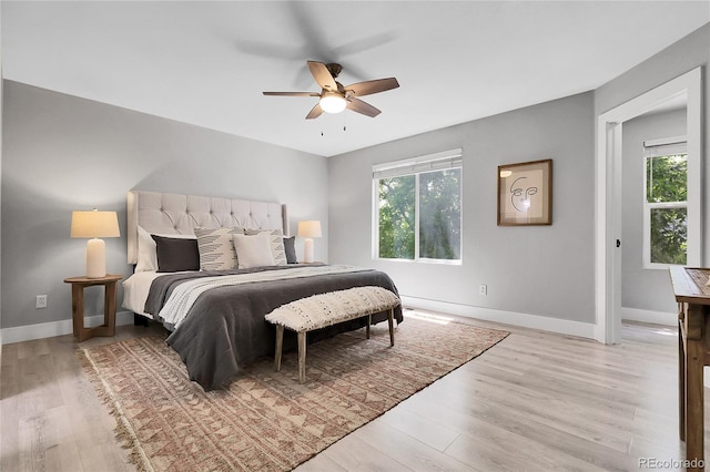 11757 W Tufts Pl, Morrison, CO 80465 - bedroom featuring multiple windows, light wood-style floors, and baseboards
