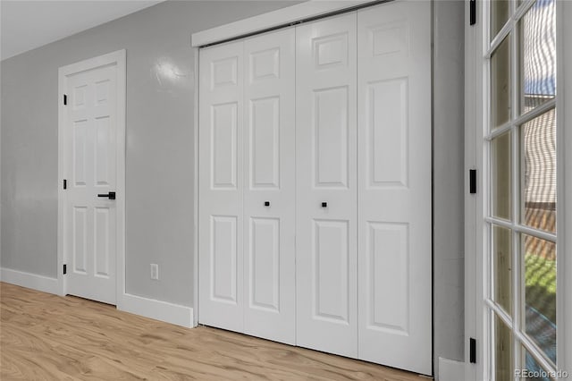11757 W Tufts Pl, Morrison, CO 80465 - unfurnished bedroom featuring multiple windows, baseboards, light wood-style flooring, and a closet