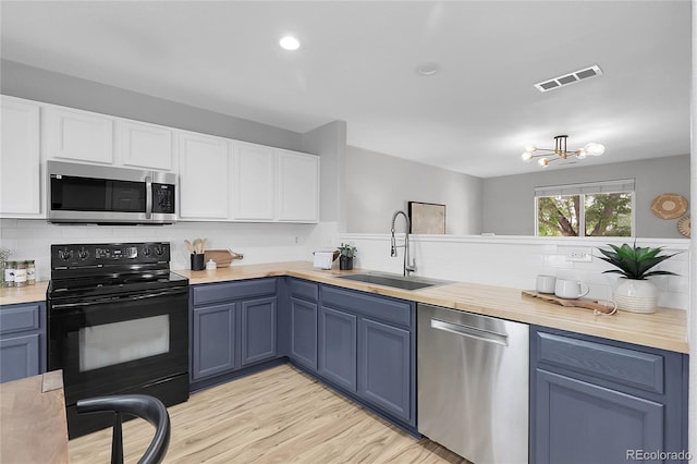 11757 W Tufts Pl, Morrison, CO 80465 - kitchen with stainless steel appliances, a sink, decorative backsplash, white cabinets, and light wood-style floors