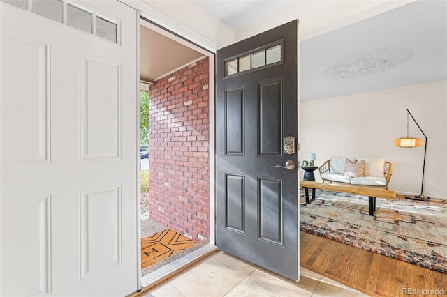 entryway featuring light hardwood / wood-style flooring and brick wall