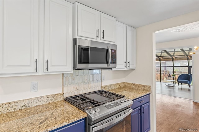 kitchen featuring blue cabinetry, stainless steel appliances, light hardwood / wood-style flooring, and white cabinets