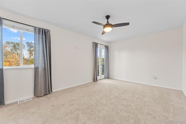 carpeted spare room featuring ceiling fan