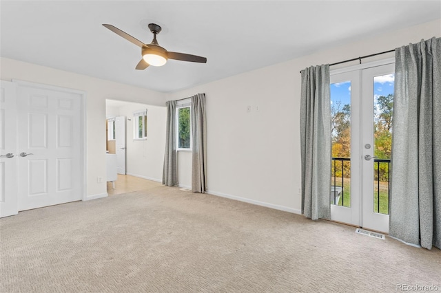 spare room with french doors, ceiling fan, light carpet, and plenty of natural light