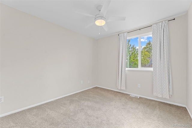 carpeted spare room featuring ceiling fan