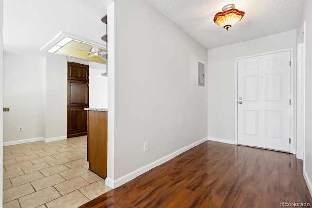 entrance foyer featuring electric panel, a textured ceiling, and light wood-type flooring