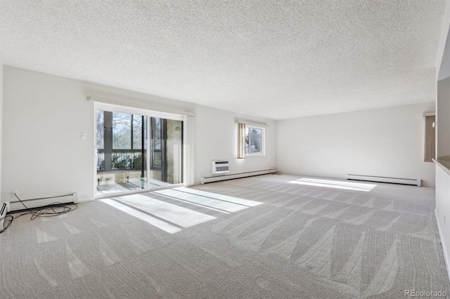 interior space with a textured ceiling, baseboard heating, and a wealth of natural light