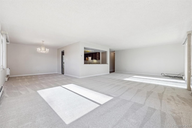 unfurnished living room with a chandelier, a textured ceiling, and light colored carpet