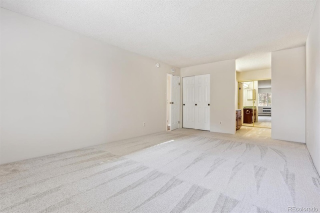 carpeted spare room featuring a textured ceiling