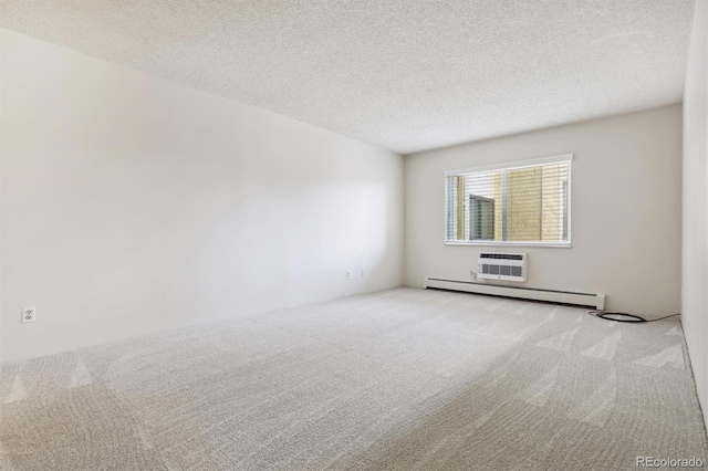 empty room featuring a textured ceiling, light carpet, and a baseboard heating unit