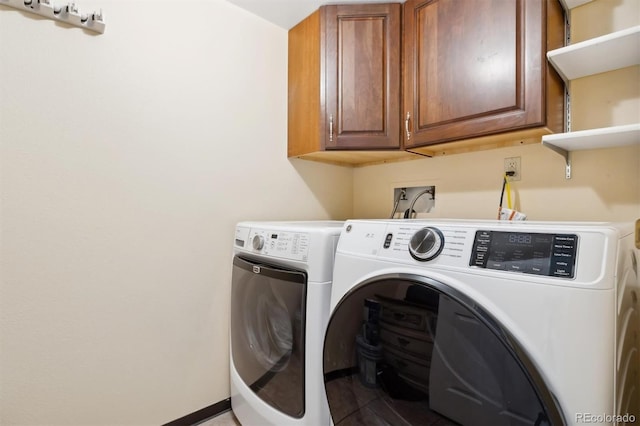 laundry room with washing machine and clothes dryer and cabinets