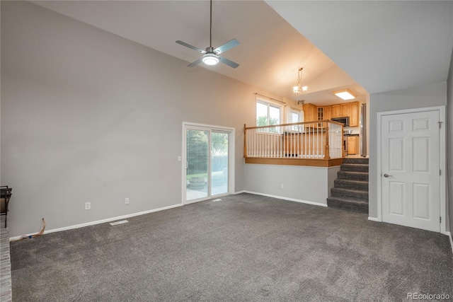 773 S Dearborn Cir, Aurora, CO 80012 - unfurnished living room with dark carpet, vaulted ceiling, stairs, ceiling fan, and a chandelier