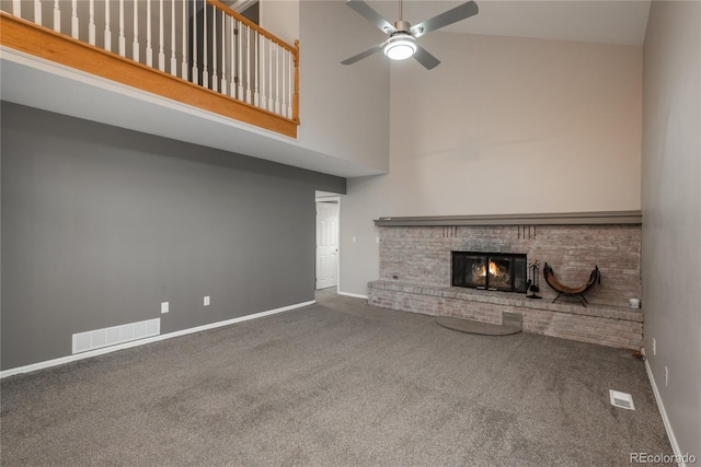 773 S Dearborn Cir, Aurora, CO 80012 - unfurnished living room featuring carpet floors, a towering ceiling, a brick fireplace, and a ceiling fan