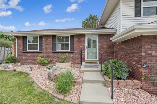 7323 Upham Ct, Arvada, CO 80003 - view of exterior entry featuring brick siding and a shingled roof