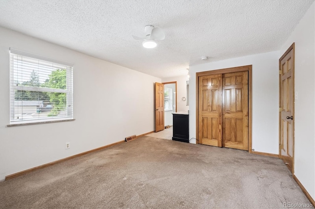 7323 Upham Ct, Arvada, CO 80003 - unfurnished bedroom featuring light colored carpet, a textured ceiling, and ensuite bathroom