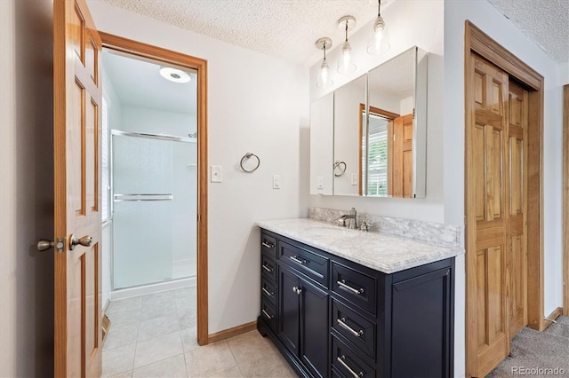7323 Upham Ct, Arvada, CO 80003 - full bathroom featuring vanity, a stall shower, a textured ceiling, and tile patterned flooring