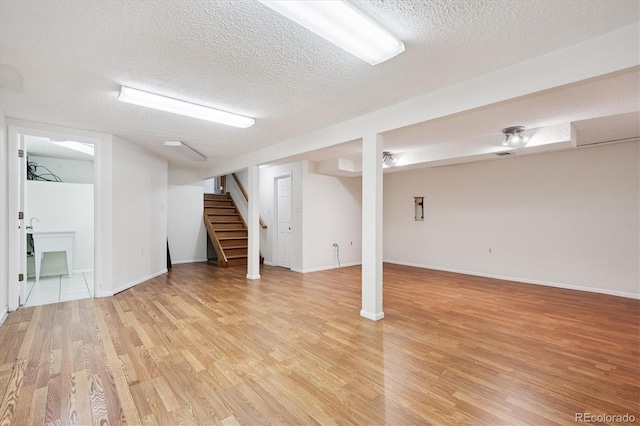 7323 Upham Ct, Arvada, CO 80003 - finished basement with light wood finished floors, a textured ceiling, and stairs