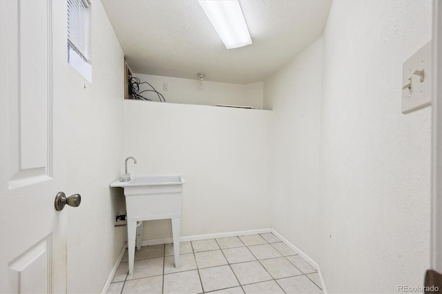 7323 Upham Ct, Arvada, CO 80003 - laundry area with light tile patterned floors and baseboards